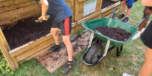Collégiens qui transvasent le contenu du bac d'apports vers le bac de maturation.