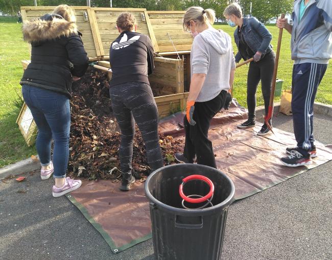 Voisins qui vident un bac d'apports pour transvaser le contenu dans un bac de maturation.
