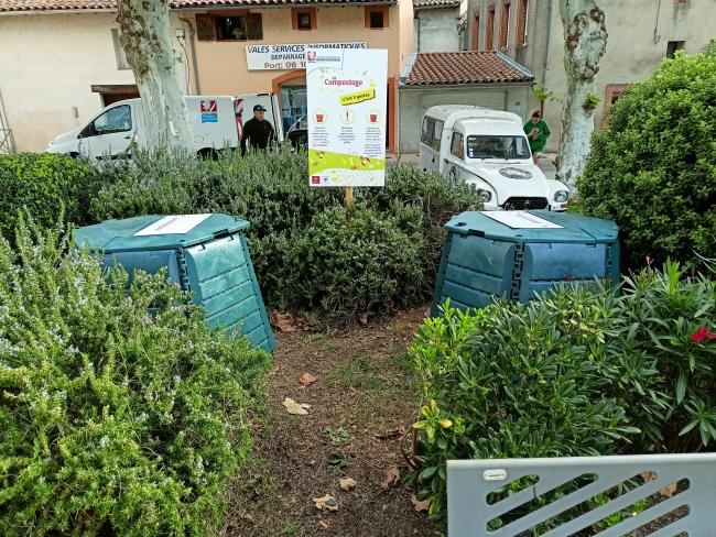 Les composteurs sont situés sur le petit espace vert de la place. Le bac de dépôts fait face au bac de matière sèche