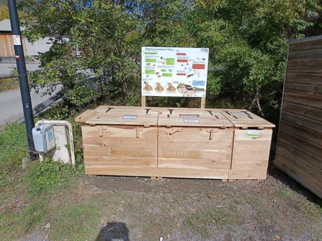 Emplacement de la plateforme sur le point de collecte à l'entrée du Village. Module en bois avec panneau explicatif.