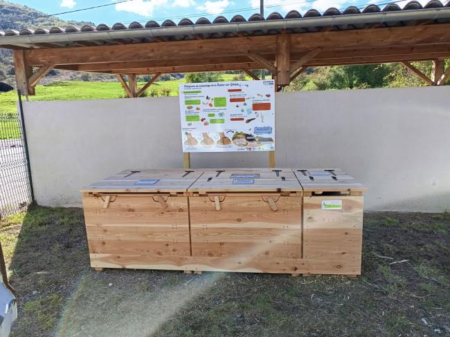 Emplacement de la plateforme sur le point de collecte à l'entrée du Village. Module en bois avec panneau explicatif.