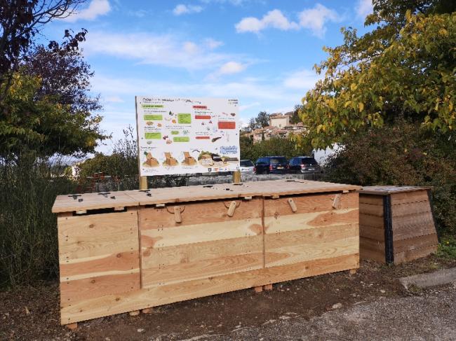 Emplacement de la plateforme sur la place Bellevue en haut du Village. Module en bois avec panneau explicatif.