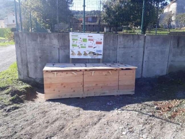 Emplacement de la plateforme à proximité du terrain de pétanque. Module en bois avec panneau explicatif.