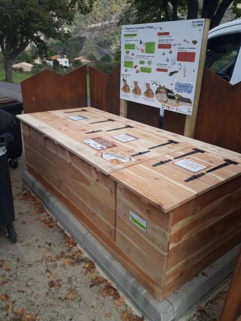 Emplacement de la plateforme à l'entrée du Village. Module en bois avec panneau explicatif.
