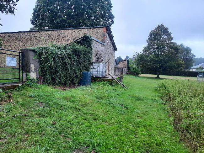 Les composteurs contre le mur dans l'espace du jardin pédagogique à l'arrière de l'école